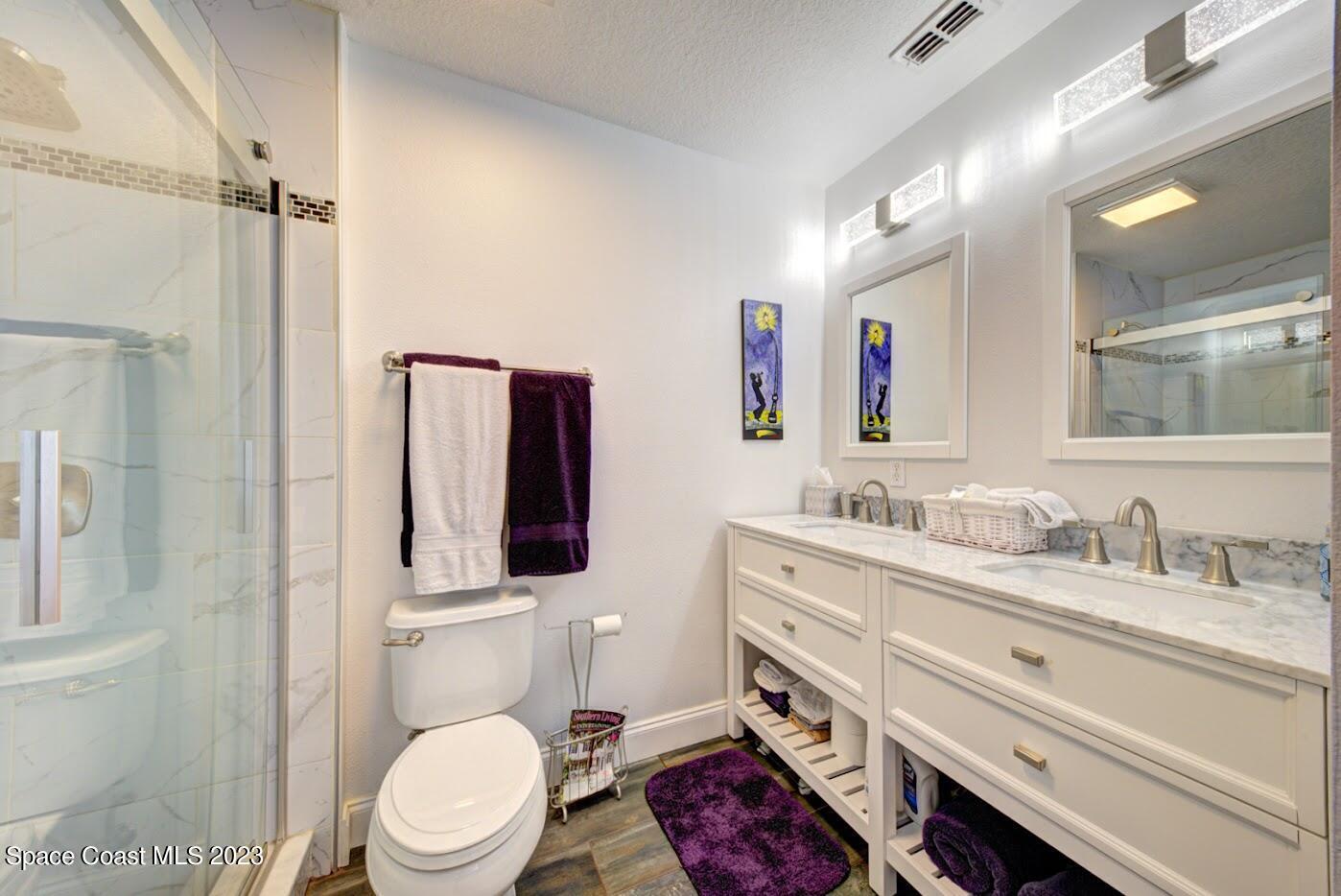 2760 Revolution Street, Unit 103 Melbourne, FL 32935 - Photo 27 of 40 a bathroom with a granite countertop toilet sink and mirror