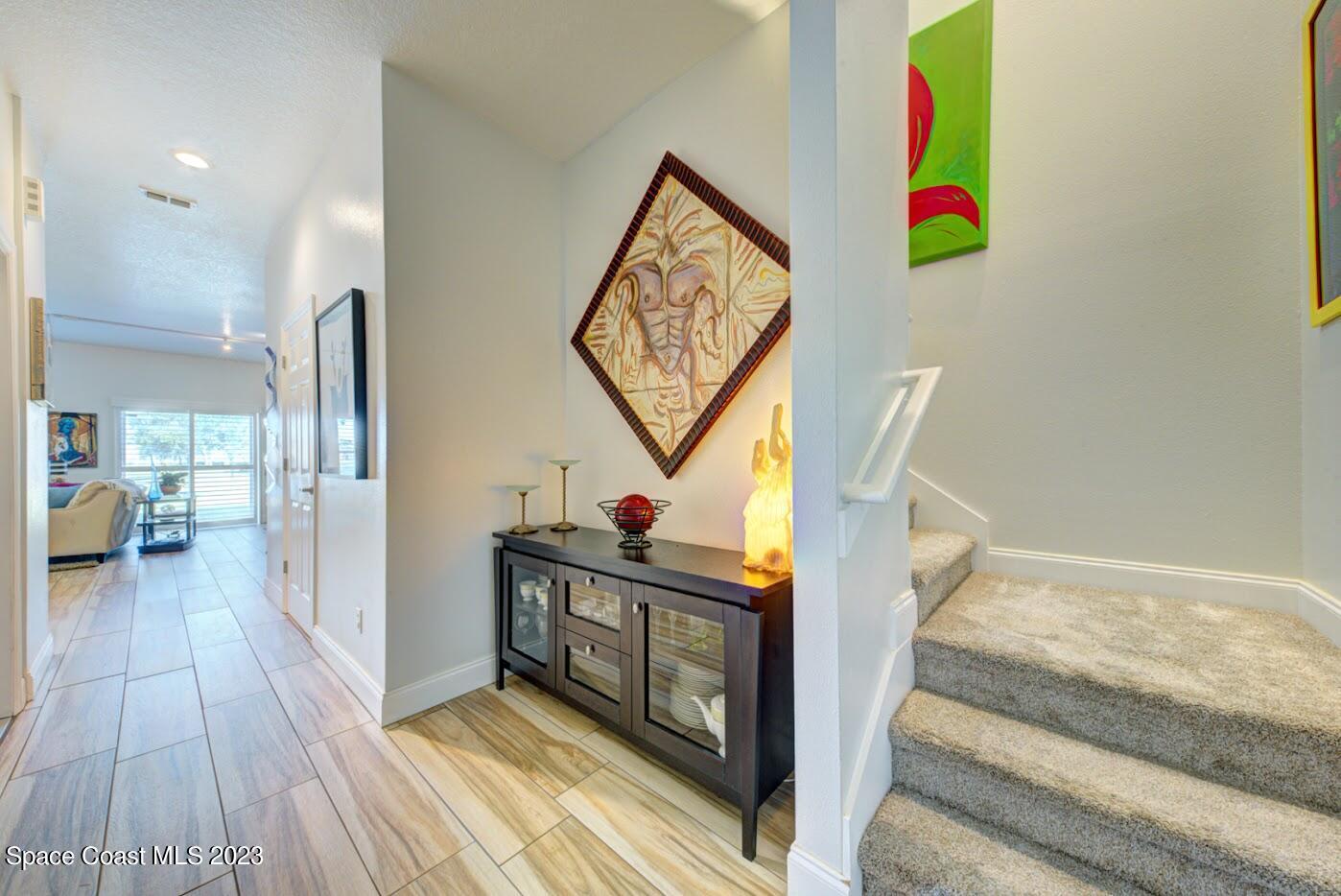 2760 Revolution Street, Unit 103 Melbourne, FL 32935 - Photo 3 of 40 a view of hallway with wooden floor and stairs
