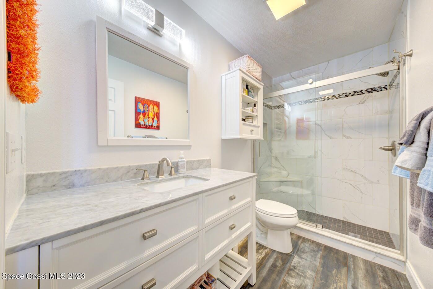 2760 Revolution Street, Unit 103 Melbourne, FL 32935 - Photo 32 of 40 a bathroom with a granite countertop sink mirror vanity and toilet