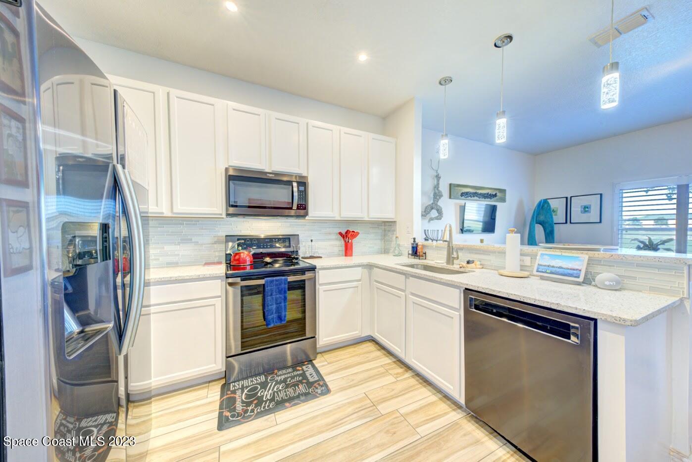 2760 Revolution Street, Unit 103 Melbourne, FL 32935 - Photo 6 of 40 a kitchen with stainless steel appliances kitchen island granite countertop a sink and a stove