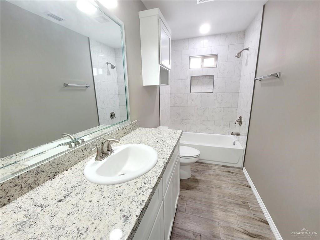 1420 Alta Vista Drive, Unit 4 Weslaco, TX 78596 - Photo 11 of 14 a bathroom with a sink a toilet and shower