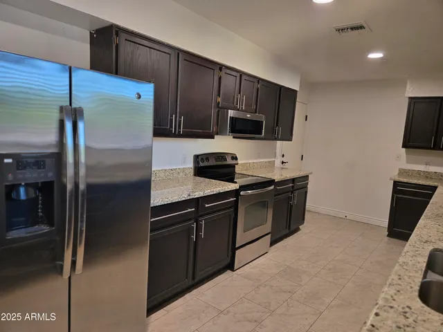 a kitchen with granite countertop a sink and steel stainless steel appliances