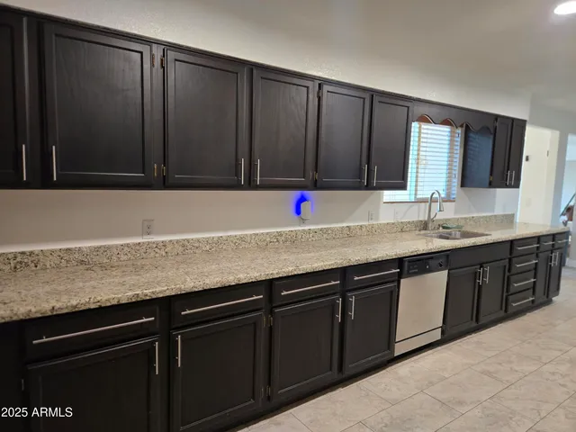 a large kitchen with stainless steel appliances a stove a sink dishwasher and a microwave oven on the blue kitchen countertops