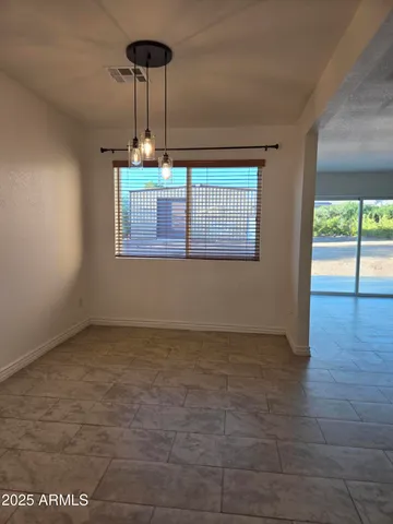 a view of empty room with window and ceiling fan