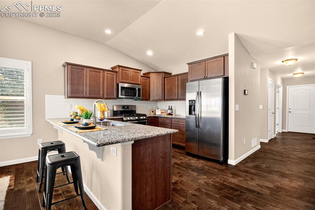 4293 Hessite Loop Colorado Springs, CO 80938 - Photo 11 of 37 a kitchen with stainless steel appliances granite countertop a refrigerator stove microwave and sink