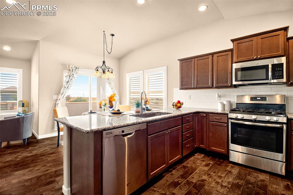 4293 Hessite Loop Colorado Springs, CO 80938 - Photo 13 of 37 a kitchen with stainless steel appliances granite countertop a stove microwave and sink