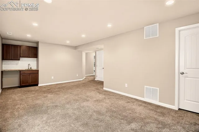 a view of an empty room with kitchen