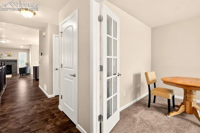 a view of a hallway to a livingroom with furniture wooden floor and windows