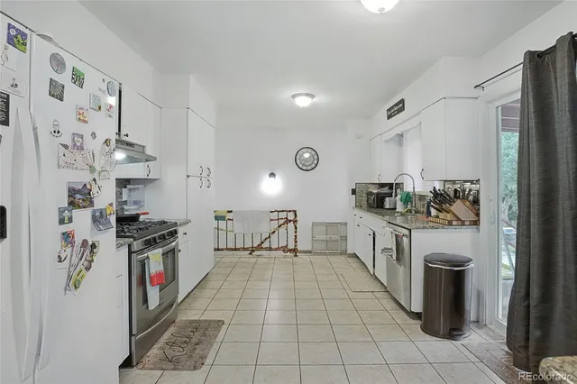 a kitchen with stainless steel appliances granite countertop a refrigerator and a stove top oven