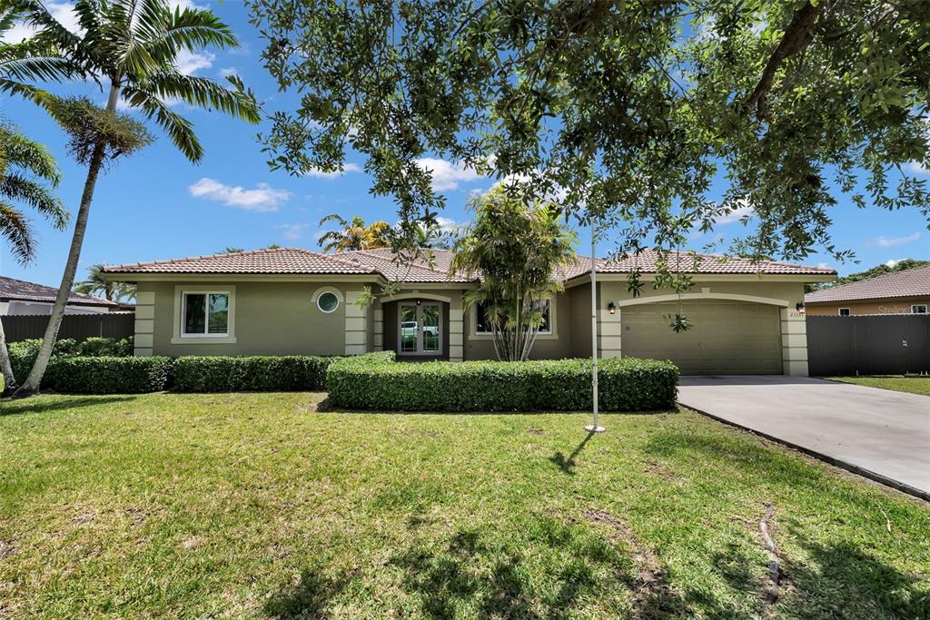 21131 Southwest 128th Court Miami, FL 33177 - Photo 1 of 24 a front view of a house with a yard and garage