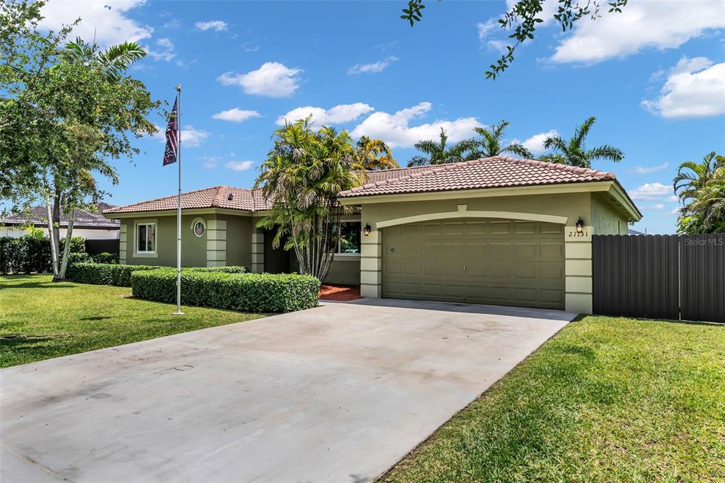 21131 Southwest 128th Court Miami, FL 33177 - Photo 3 of 24 a front view of a house with a yard and garage