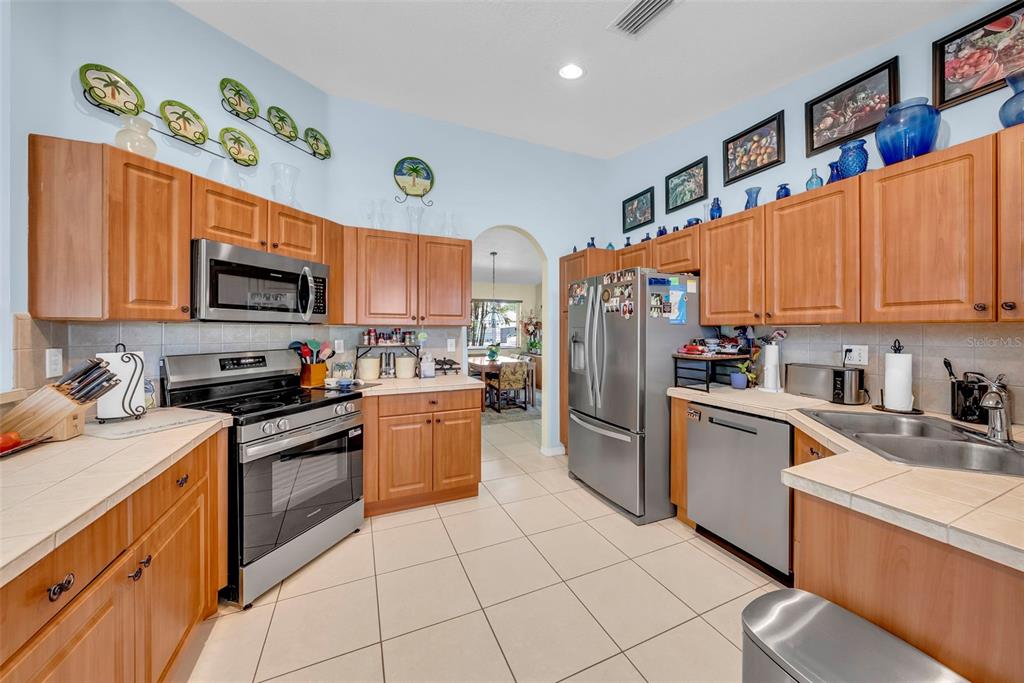 21131 Southwest 128th Court Miami, FL 33177 - Photo 9 of 24 a kitchen with granite countertop stainless steel appliances and wooden cabinets