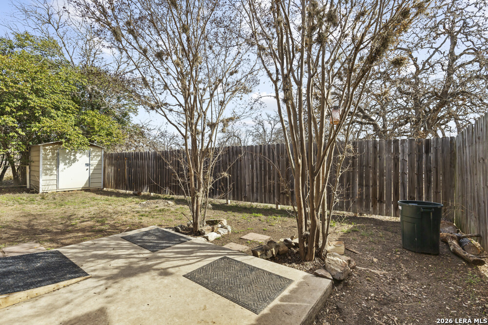 292 Montague Drive Bandera, TX 78003 - Photo 21 of 24 a view of a backyard with wooden fence and a large tree