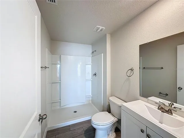 a bathroom with a sink toilet vanity and shower