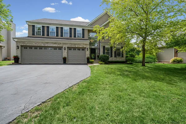 a front view of a house with a garden and yard