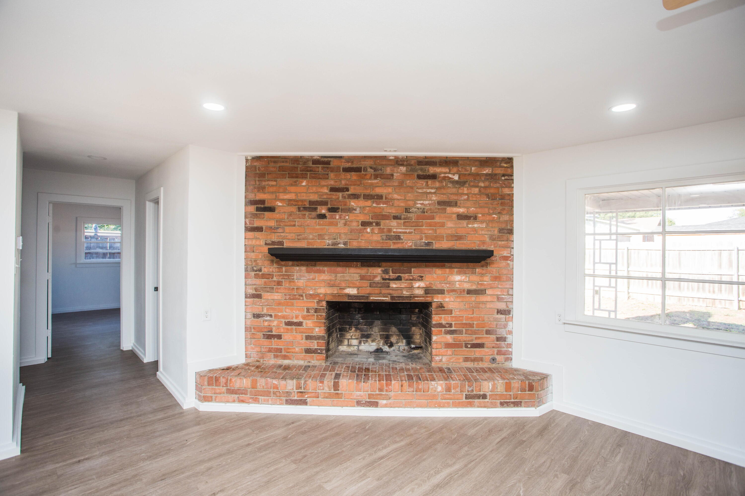 6004 Vernon Avenue Lubbock, TX 79412 - Photo 15 of 34 a living room with a fireplace and wooden floor