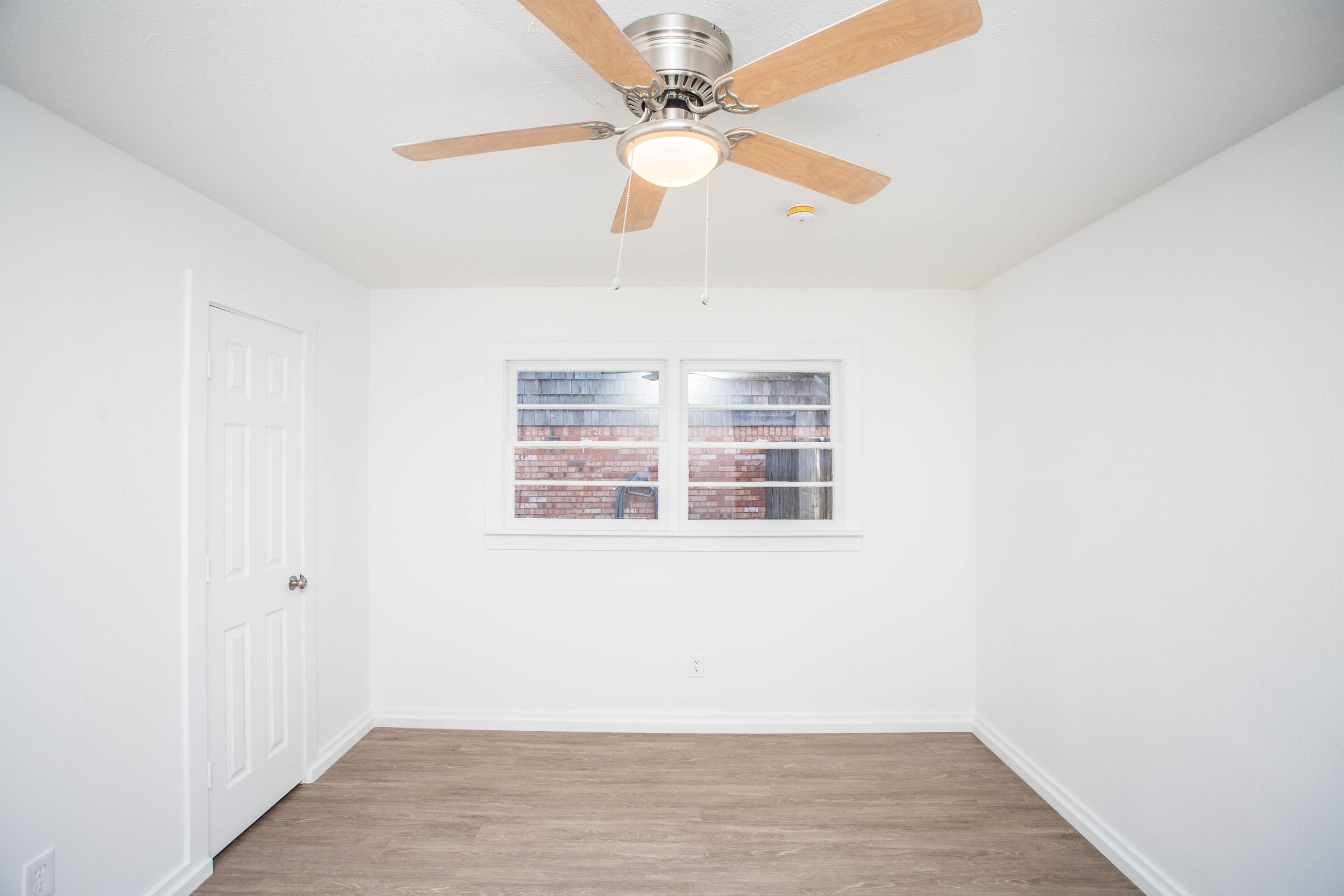 6004 Vernon Avenue Lubbock, TX 79412 - Photo 18 of 34 an empty room with wooden floor fan and windows