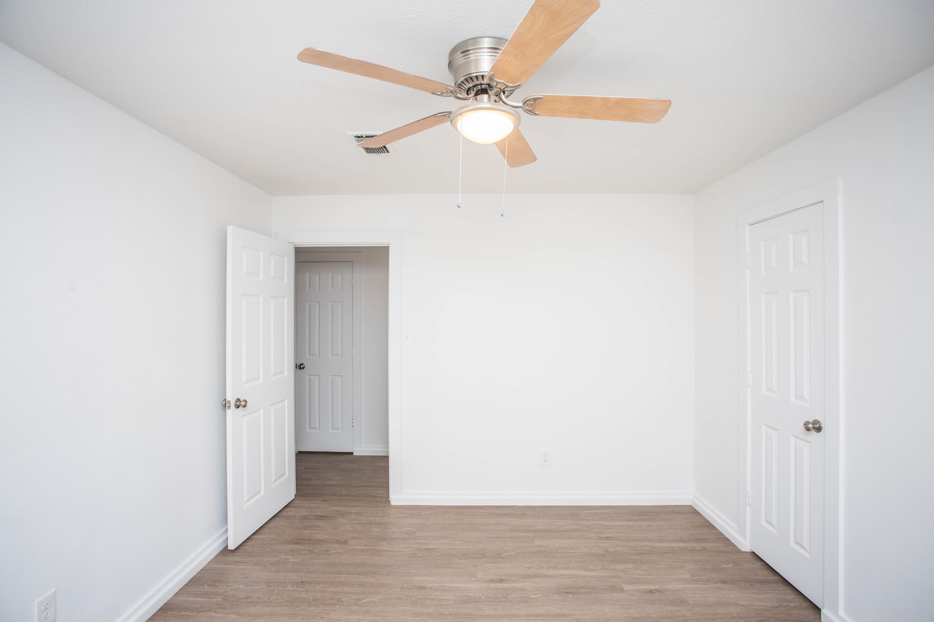 6004 Vernon Avenue Lubbock, TX 79412 - Photo 19 of 34 an empty room with wooden floor fan and windows