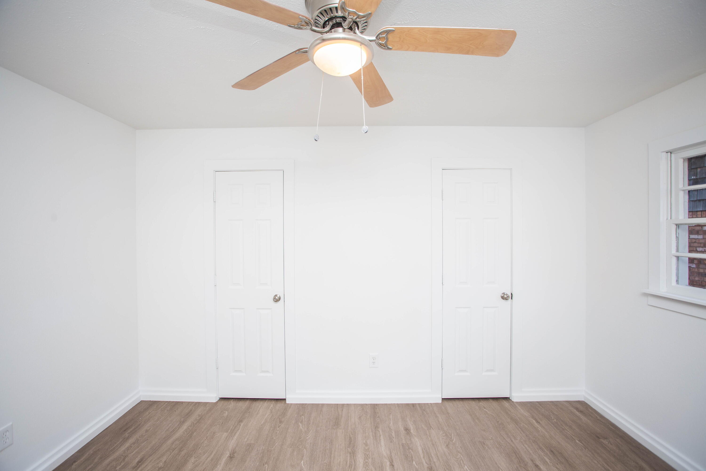 6004 Vernon Avenue Lubbock, TX 79412 - Photo 23 of 34 an empty room with a ceiling fan and wooden floor