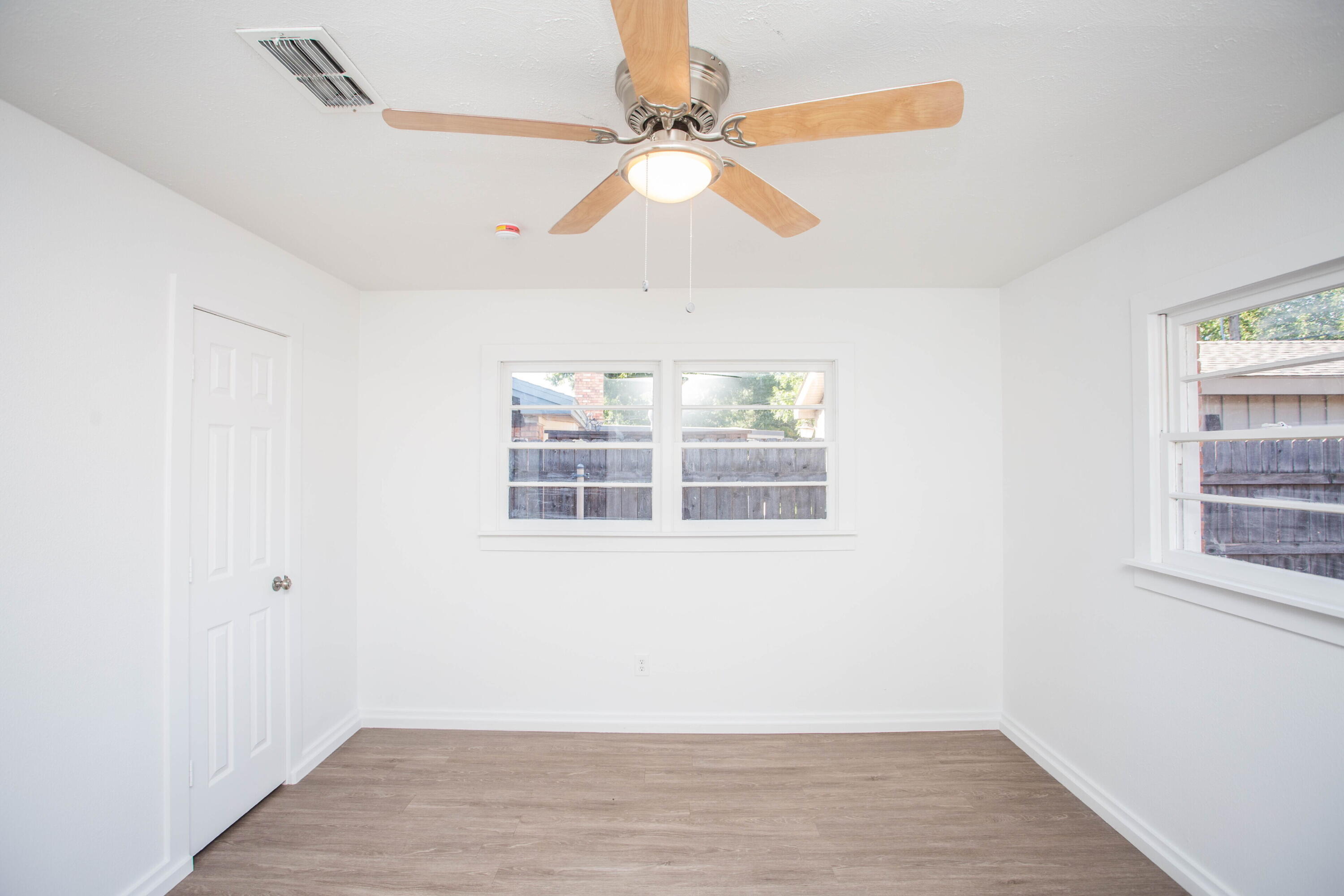 6004 Vernon Avenue Lubbock, TX 79412 - Photo 24 of 34 an empty room with wooden floor fan and windows
