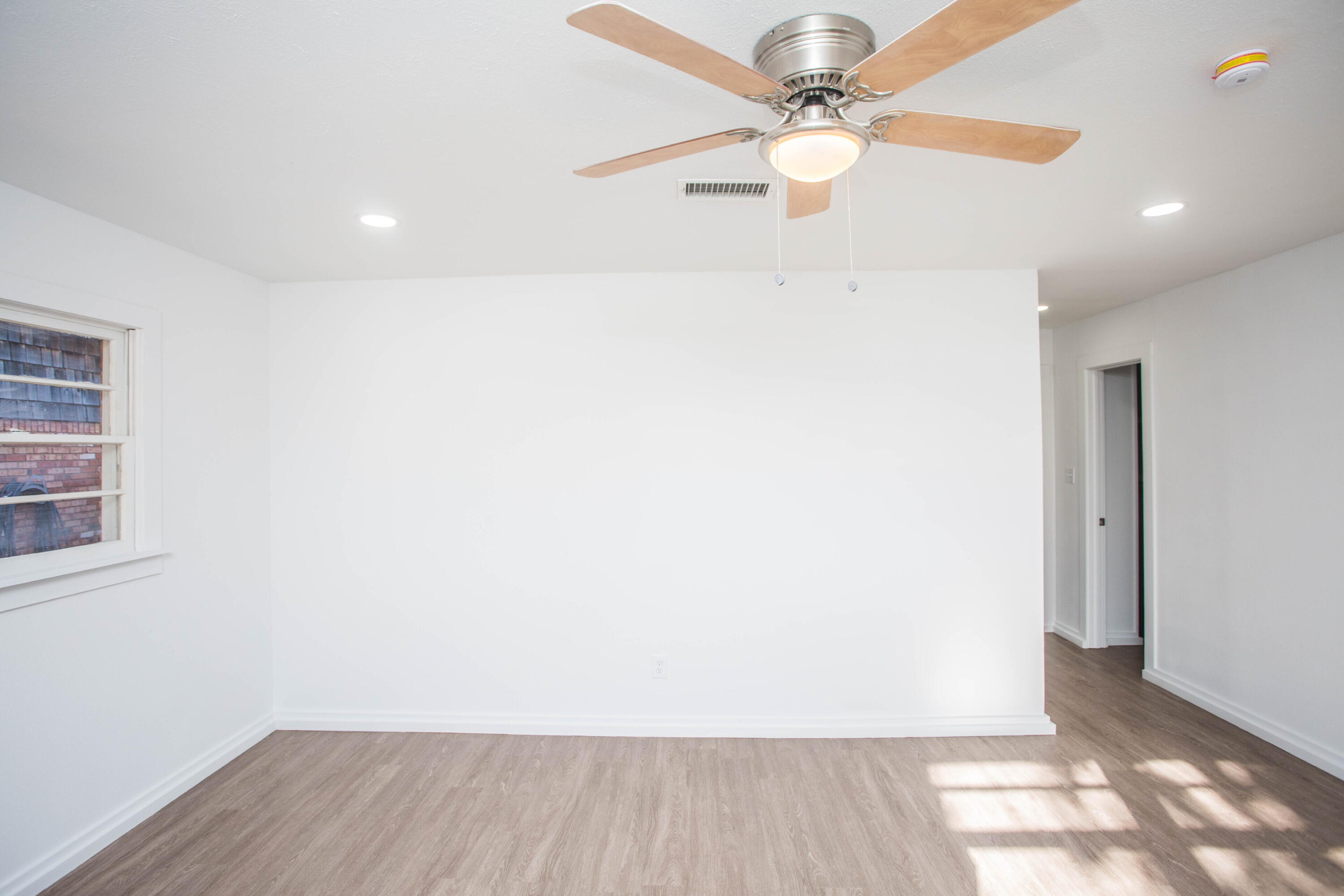 6004 Vernon Avenue Lubbock, TX 79412 - Photo 32 of 34 an empty room with wooden floor fan and windows