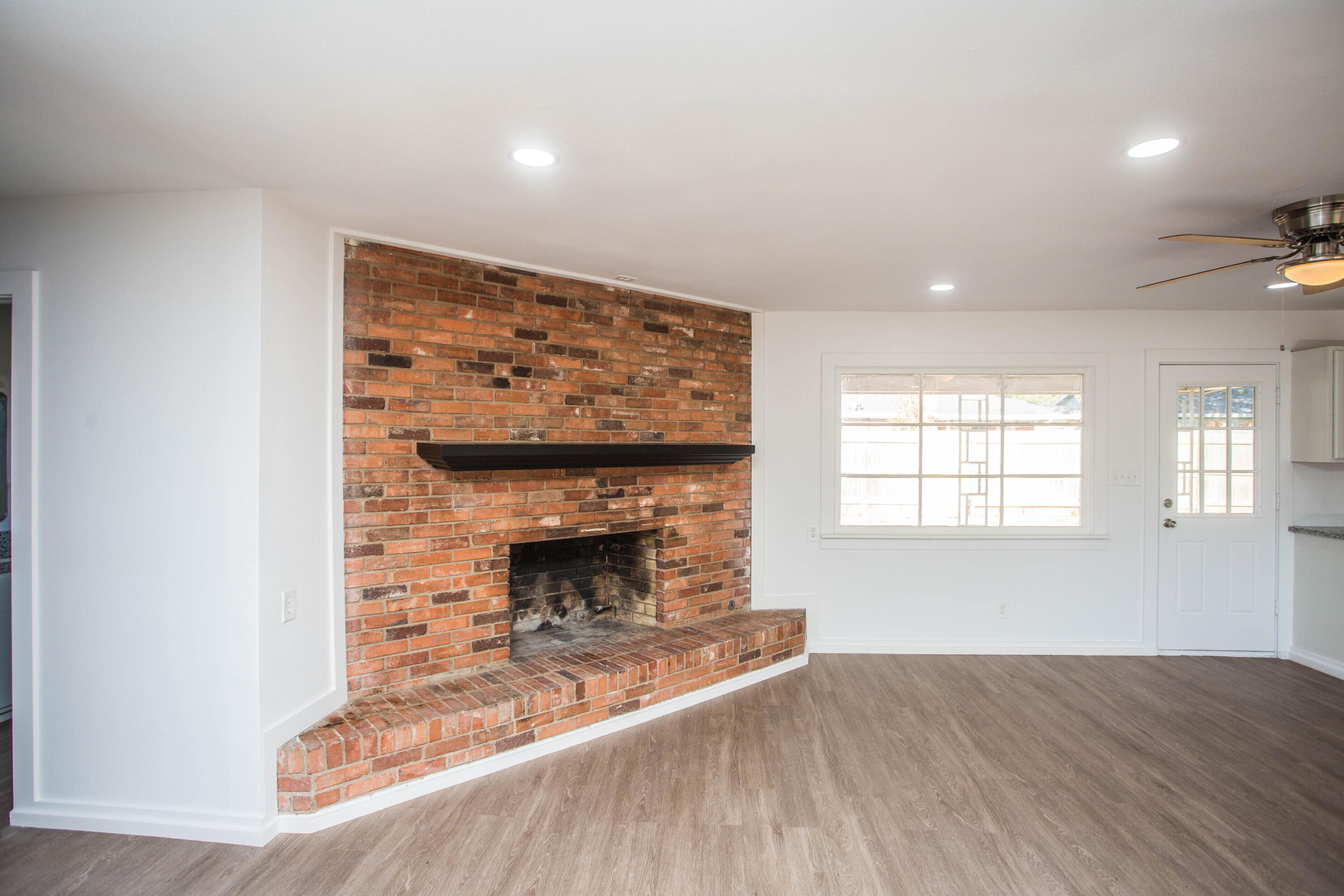 6004 Vernon Avenue Lubbock, TX 79412 - Photo 6 of 34 an empty room with windows and fireplace