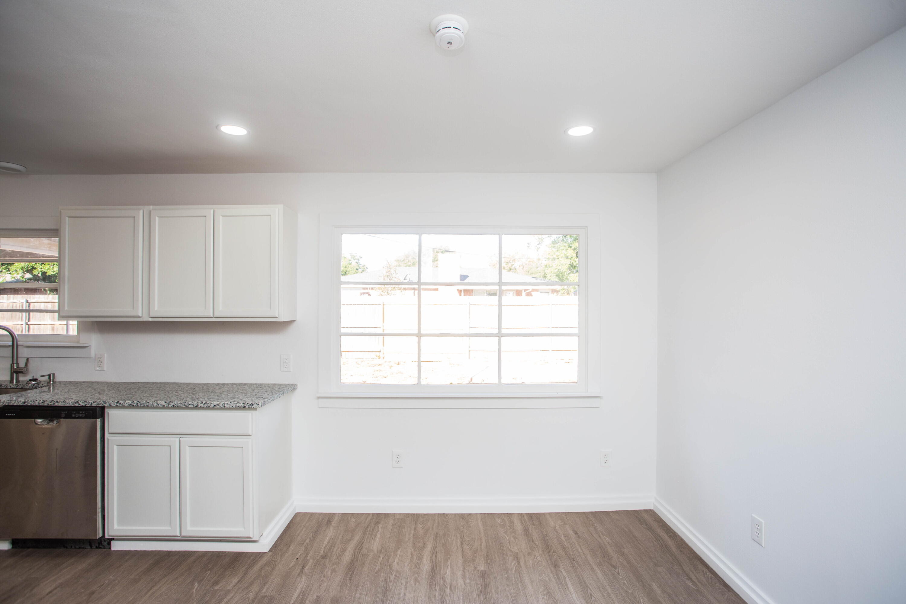 6004 Vernon Avenue Lubbock, TX 79412 - Photo 10 of 34 a kitchen with wooden floor and window