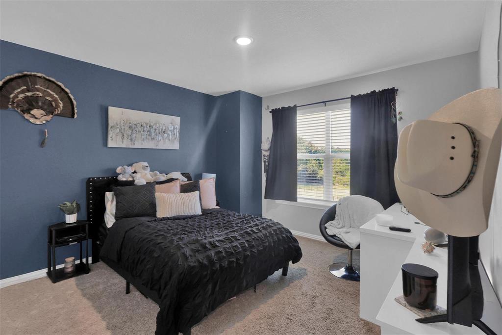 154 Chester Road Springtown, TX 76082 - Photo 22 of 40 a bedroom with a bed a mirror on dresser and a window