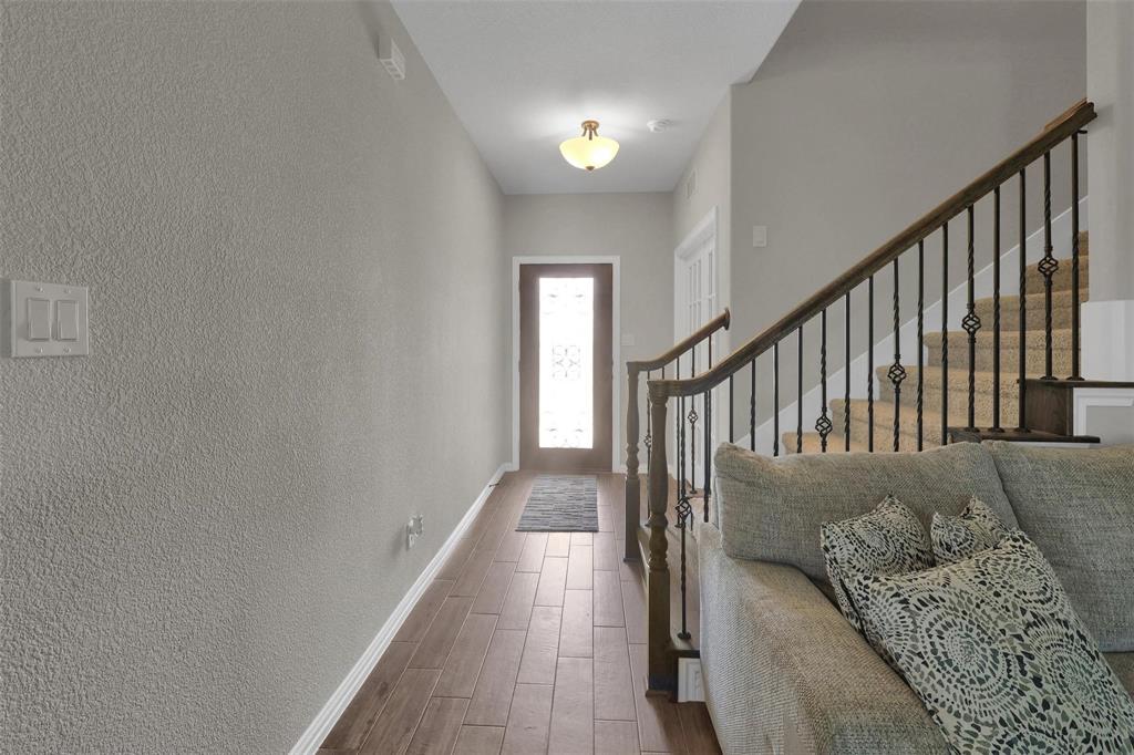 154 Chester Road Springtown, TX 76082 - Photo 4 of 40 a view of a hallway to a livingroom with wooden floor and stairs