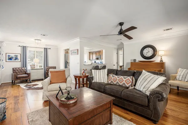 a living room with furniture a clock on wall and a window