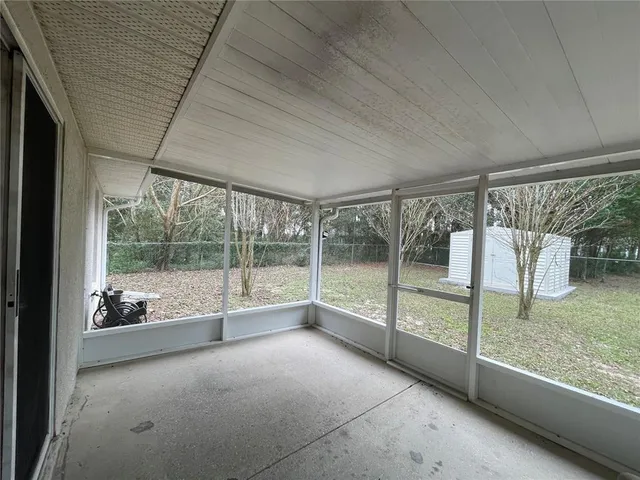 a view of an empty room with wooden floor and a glass door
