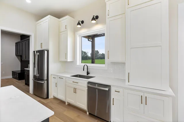 a kitchen with white cabinets and stainless steel appliances