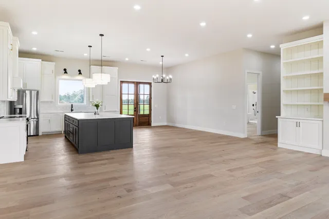 a large room with stainless steel appliances kitchen island a large counter top and a floors