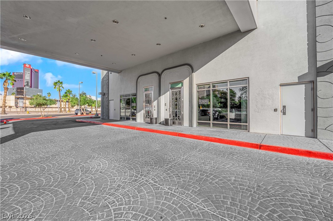 360 East Desert Inn Road, Unit 607 Las Vegas, NV 89109 - Photo 44 of 55 A grand entrance welcomes residents with a patterned paver driveway and prominent building architecture.