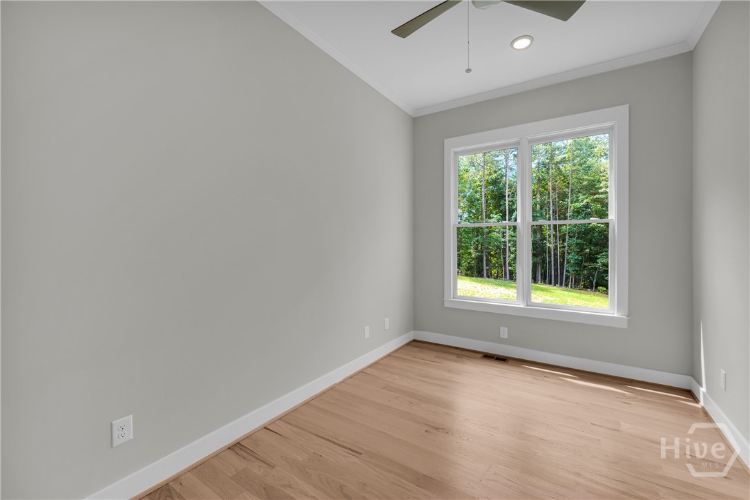 2476 St Martin Way Monroe, GA 30656 - Photo 26 of 75 Light-filled guest bedroom on main featuring a double-hung window, wood-finish flooring, a ceiling fan, recessed lighting, and crisp white trim