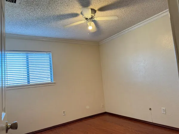 an empty room with a window and a ceiling fan