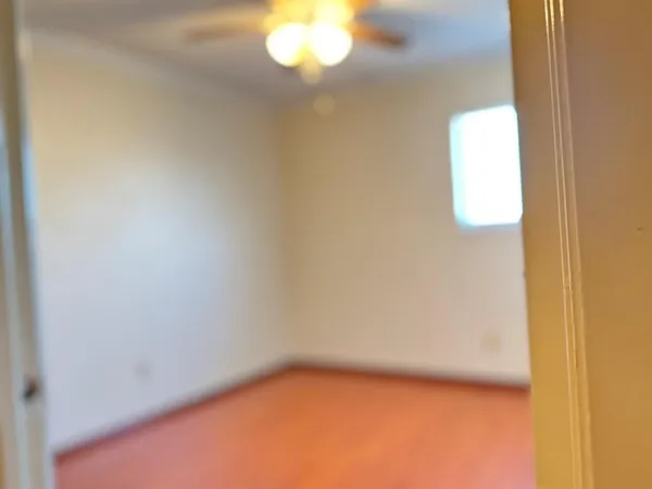 a view of a small space with wooden floor and a window