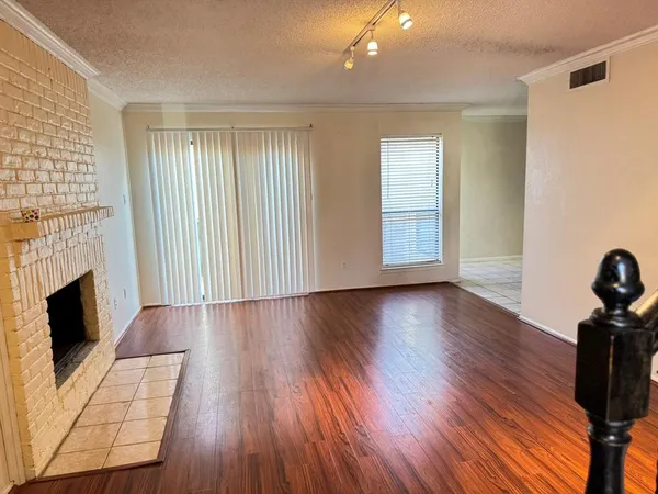 an empty room with wooden floor and fireplace