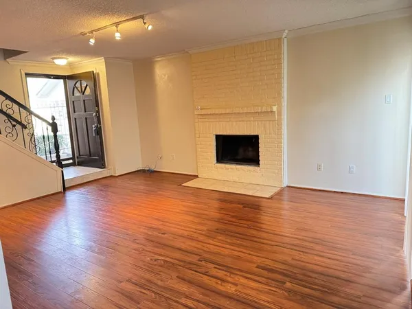 a view of empty room with wooden floor and fireplace