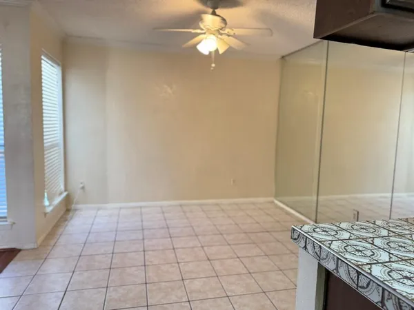 a view of an empty room and window chandelier fan