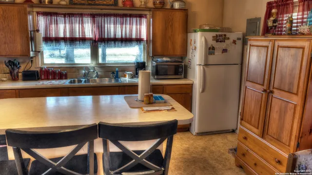 a kitchen with stainless steel appliances granite countertop a refrigerator a stove and a refrigerator with wooden floor