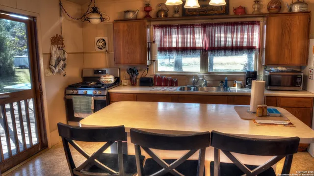 a kitchen with a table chairs and a window
