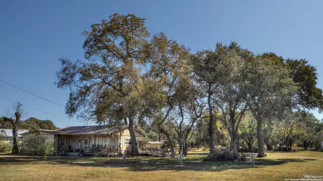 a view of a large house with a yard and a large tree