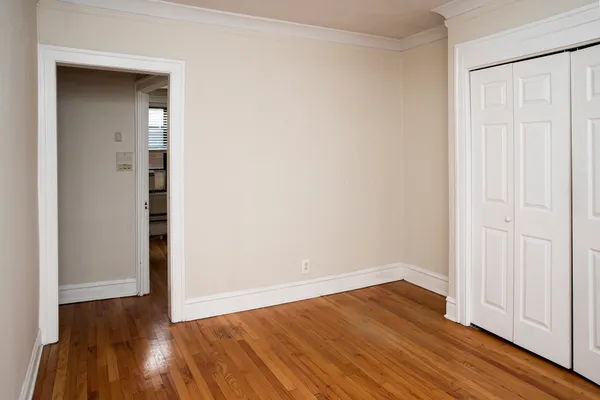 an empty room with wooden floor and closet