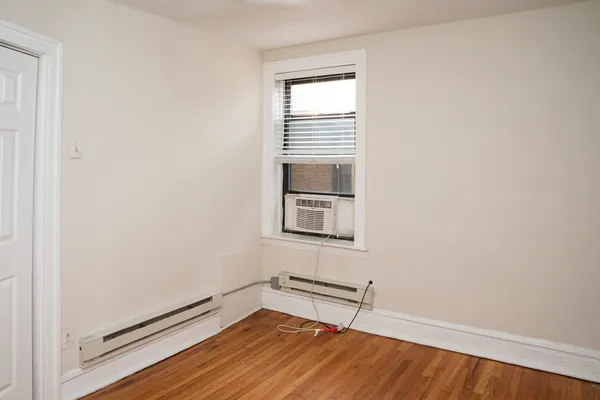 a room with a wooden floor and a window