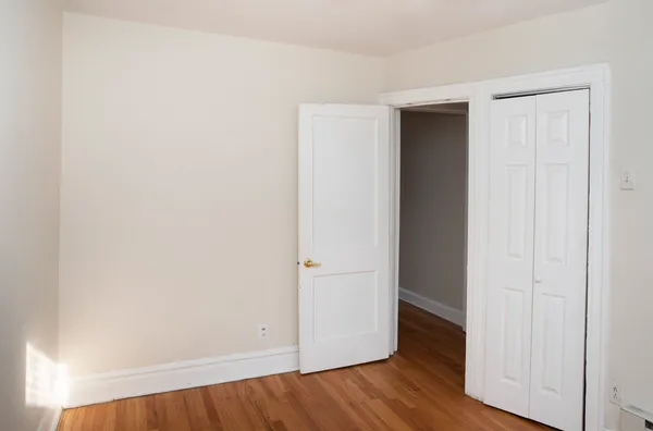 an empty room with wooden floor and closet