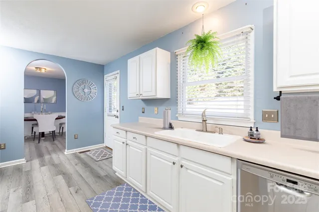 a kitchen with a sink a window and cabinets