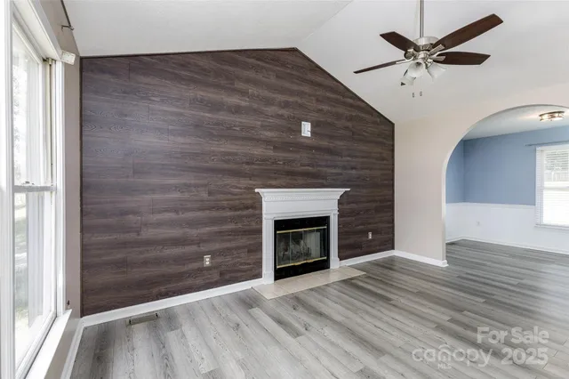wooden floor fireplace and window in an empty room