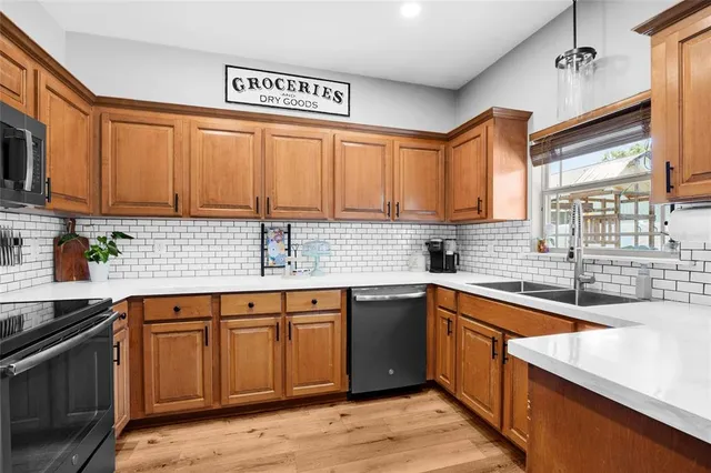 a kitchen with stainless steel appliances granite countertop a sink stove and cabinets
