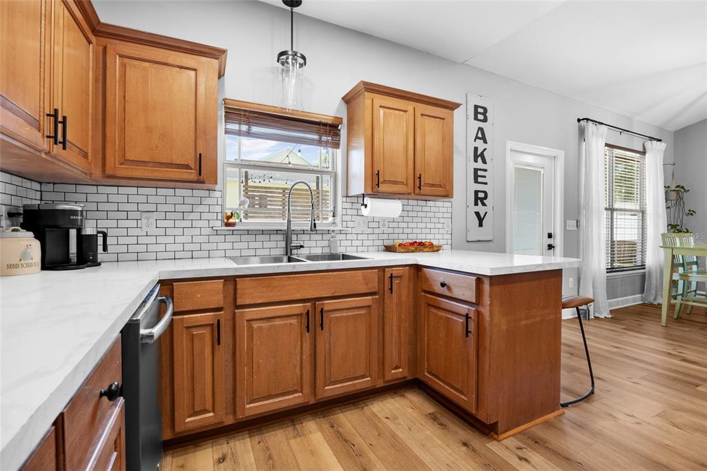 24825 Northwest 201st Road High Springs, FL 32643 - Photo 13 of 31 a kitchen with stainless steel appliances granite countertop wooden cabinets a sink a stove a dining table and chairs